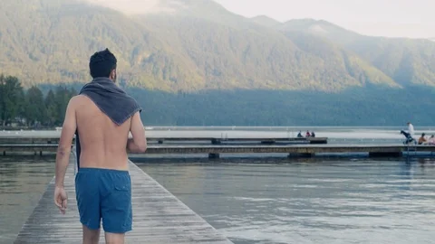 Young Man walks down dock at Cultus Lake BC Stock Footage 89913222