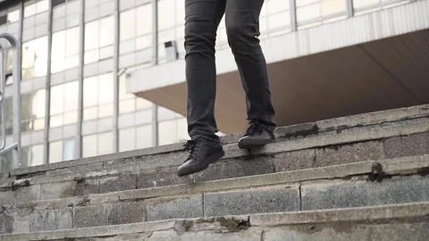 A young man walks down the steps in black sneakers. City. Stock Footage 246797446