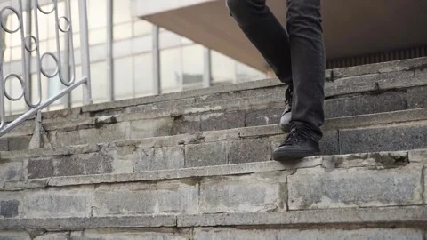 A young man walks down the steps in black sneakers. City. Stock-Footage 246966522