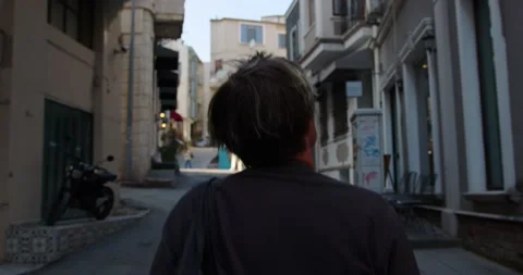 A young man walks down a street in Istanbul with historic buildings, pavements Stock Footage 237400511
