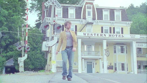 A young man walks down the street in on old town, Monticello, NY 1989. Stock Footage 272247674