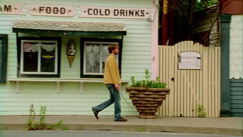 A young man walks down the street in on old town, Monticello, NY 1989. Stock Footage 272257035