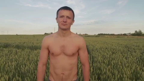 A young man walks the field of wheat. Stock Footage 78654116