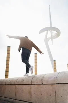 Young man walks on ledge symbolizing freedom Stock-Fotos