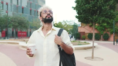 Young Man Walks Through City Park with Coffee Stock Footage 312639862