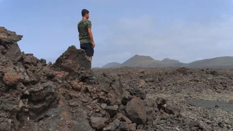 Young man walks through a sea of  volcanic ​​lava  2 Stock Footage