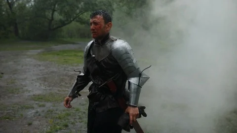 Young man walks through the smoke in the image of a medieval knight. Stock Footage 109166286