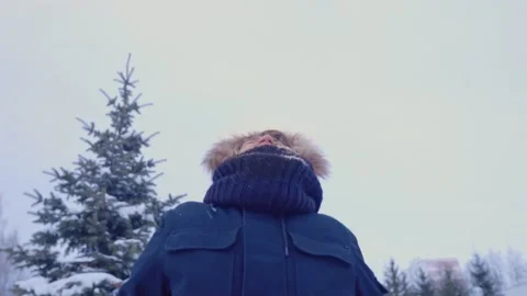Young man in a warm jacket throws snow over him Stock Footage 145065174