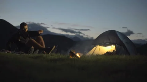 Young man warming with camp fire and walk away in nature mountain outdoor Видео 64543637