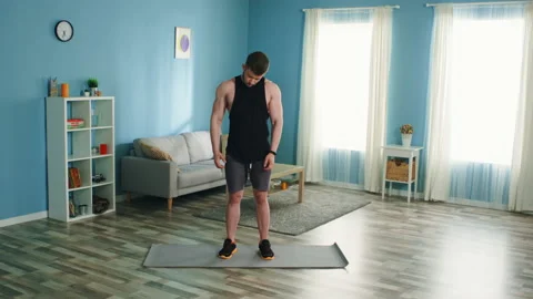 Young Man is Warming Up at Home Stock Footage 135532165