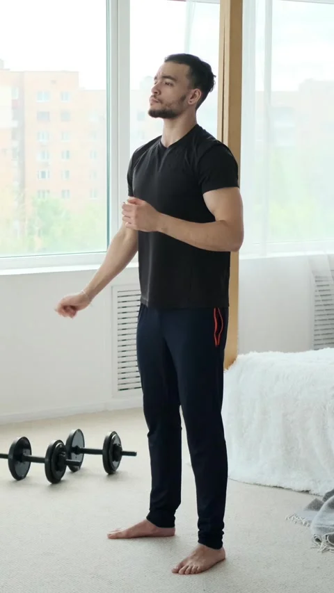 Young man warming up for a home workout in his bedroom. Stock Footage 319638425