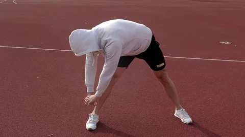 Young man warming up before running in the stadium Stock Footage 130138487