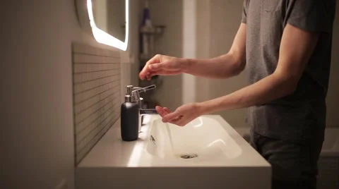 Young man washes his hands in the bathroom 스톡 동영상 60406675