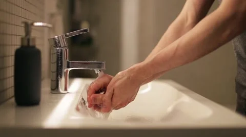 Young man washes his hands in the bathroom 스톡 동영상 60406697