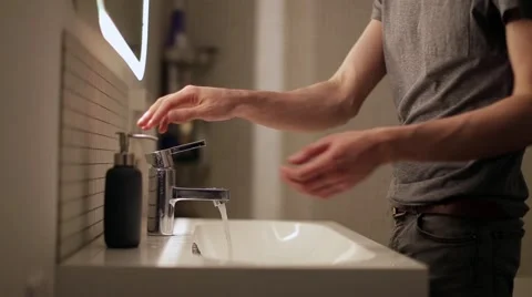 Young man washes his hands in the bathroom 스톡 동영상 60406710
