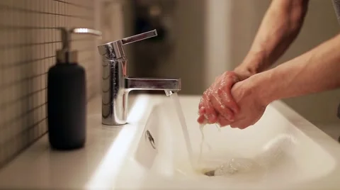 Young man washes his hands in the bathroom 스톡 동영상 60406724