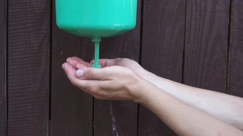A young man washes his hands in an old open green plastic sink Stock Footage 208796528