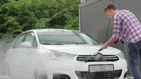 A young man washes his white car Stock-Footage 89979821