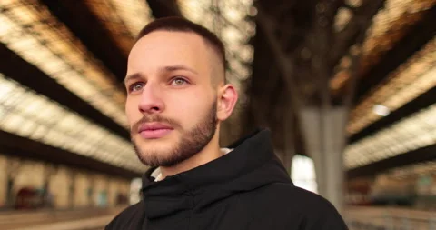 A young man watches a train leave the station. Stock Footage 247353583