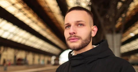 A young man watches a train leave the station. Stock Footage 247353586
