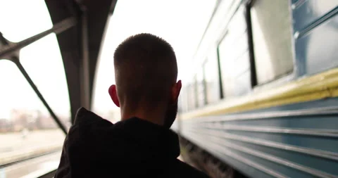 A young man watches a train leave the station. Stock Footage 247353740