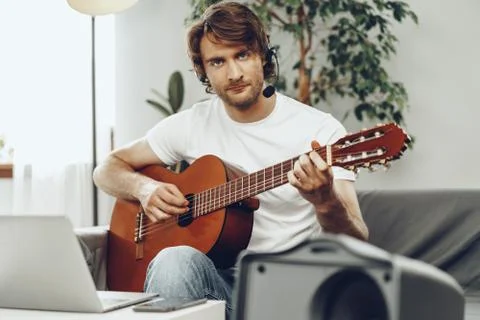 Young man watching guitar tutorial on his laptop Foto stock