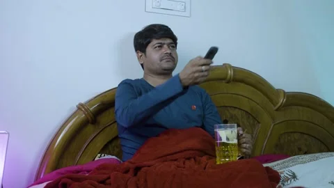 Young man watching tv on bed while drinking beer during weekend holidays - Stock Footage 170497093