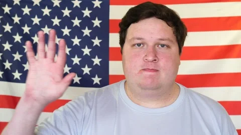 Young man waving hand on the background of an USA flag Stock Footage 107053277