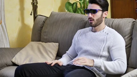Young man wearing 3d glasses reacting in surprise Stock Footage 84480937