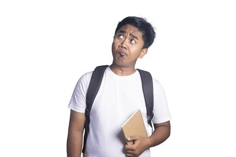 Young man wearing a backpack and holding a notebook looking up with a confu.. Stock Photos