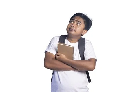 Young man wearing a backpack and clutching a notebook to his chest while lo.. Stock Photos
