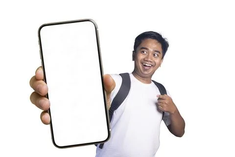 Young man wearing a backpack and pointing excitedly at a large smartphone w.. Stock Photos