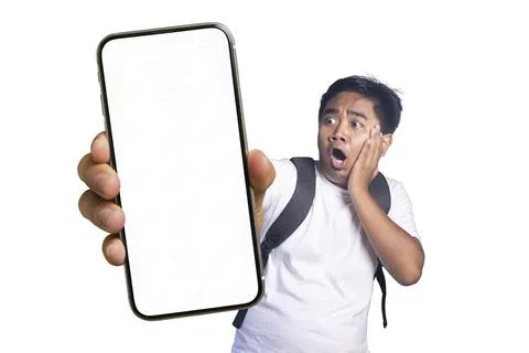 Young man wearing a backpack holding his hand to his face in shock while lo.. Stock Photos