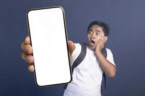 Young man wearing a backpack holding his hand to his face in shock while lo.. Stock Photos