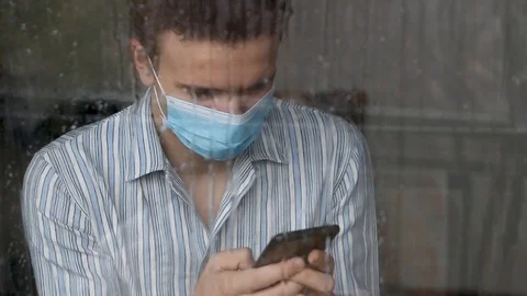 Young man wearing a face mask, sick and quaranteened Stock Footage 126100398