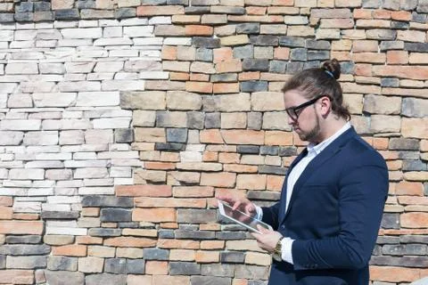 Young man wearing glasses using tablet computer outside Stock Photos