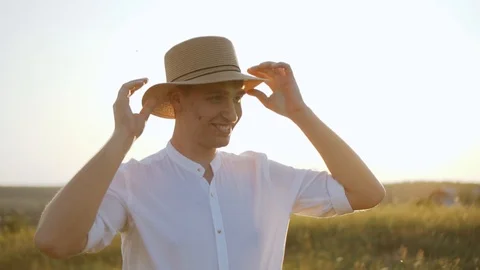 Young man wearing hat smiling outdoors at sunset in summer. Stock Footage 122559935