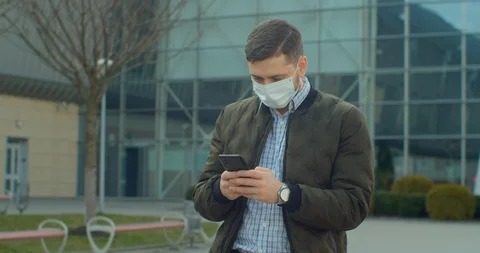 Young Man wearing Protective Face Mask use phone COVID-19 coronavirus infection Video stock 126763536