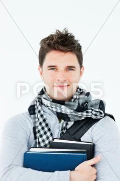 Young man wearing a scarf squeezing books against himself Stock Photos