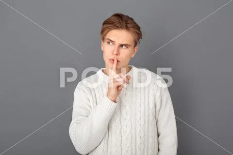 Young man wearing sweater studio isolated on grey silence gesture Stock Photos