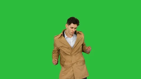 Young man wearing trench coat dancing and having fun on a Green Screen, Chroma Stock Footage