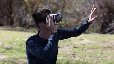 Young man wearing virtual reality goggles outdoor Stock Footage 73579933