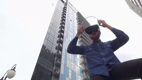 Young Man wearing virtual reality goggles outdoor Stock Footage 74058851