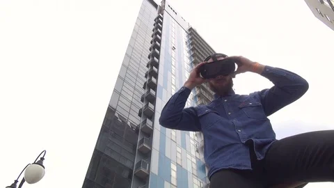 Young Man wearing virtual reality goggles outdoor Stock Footage 74058872