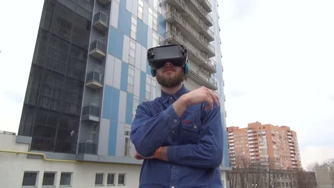 Young Man wearing virtual reality goggles outdoor Stock Footage 74058965