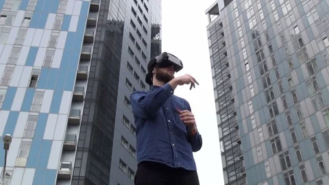 Young Man wearing virtual reality goggles outdoor Stock Footage 74059198