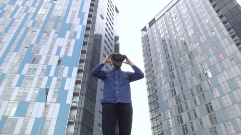 Young Man wearing virtual reality goggles outdoor Stock Footage 74059332