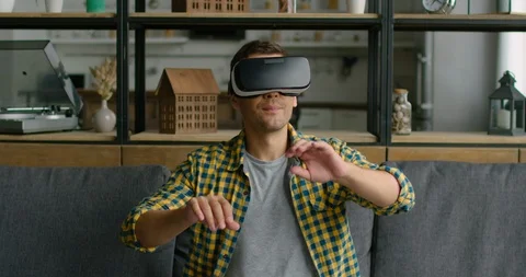 Young man wearing virtual reality headset, using gestures to control images Stock Footage 113624738