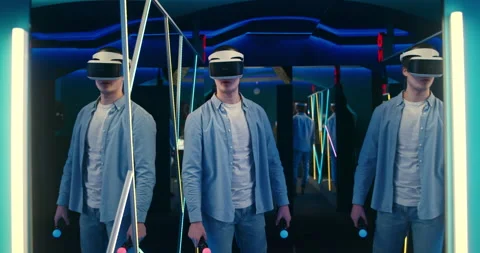 Young man wearing virtual reality glasses looks amazed while standing in room Video stock 150321781