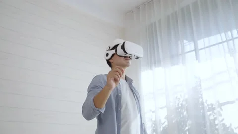 Young man wearing Virtual reality glass touching simulation screen on the air Stock Footage 166034207